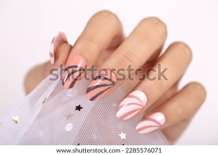 Female hand with silver nail design. Glitter silver nail polish manicure. Model hand with perfect manicure hold white lace fabric on white background.