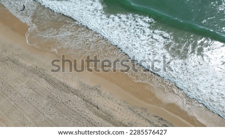 Sandy beach with waves (drone shot) at Surfers Paradise Beach on the Gold Coast