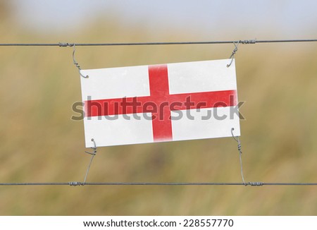 Border fence - Old plastic sign with a flag - England