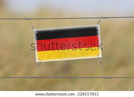 Border fence - Old plastic sign with a flag - Germany