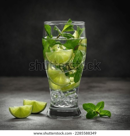 Mojito cocktail. Summer refreshing drink on a dark background. Side view, selective focus, copy space. Square image.