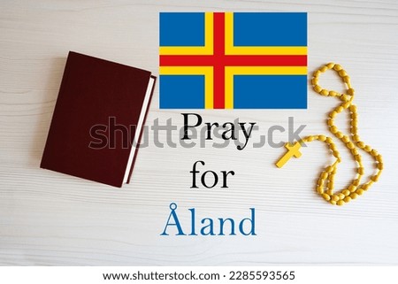 Pray for Aland. Rosary and Holy Bible background.