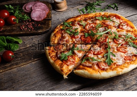 Appetizing pizza with ham on a wooden background Royalty-Free Stock Photo #2285596059