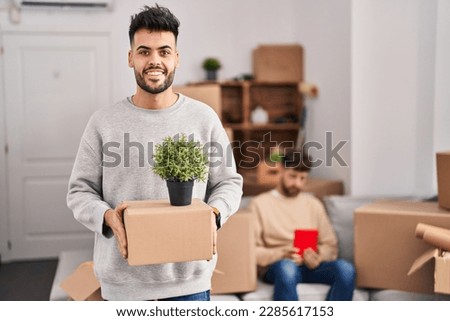 Homosexual couple moving to a new home smiling with a happy and cool smile on face. showing teeth.  Royalty-Free Stock Photo #2285617153