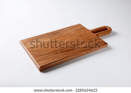 Dark brown rectangle wooden background with a handle positioned on the top right shot isolated on white background with soft shadows high angle view Royalty-Free Stock Photo #2285624623
