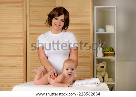 Portrait of a young beautiful mother to massage your baby 
