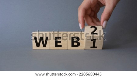 WEB 2 or 1 symbol. Businessman hand Turnes cube and changes word WEB 1 to WEB 2. Beautiful grey background. Business and WEB concept. Copy space