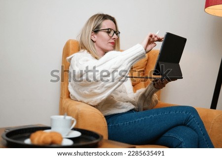 beautiful young woman drinking coffee and using laptop at home.