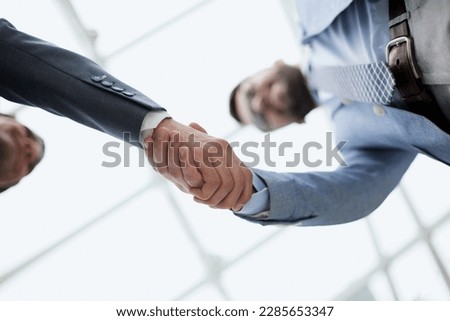 Business partners shaking hands in meeting hall bottom view Royalty-Free Stock Photo #2285653347