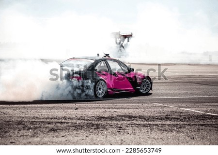 pink car drifting, Blurred image diffusion race drift car with lots of smoke from burning tires on speed track Royalty-Free Stock Photo #2285653749