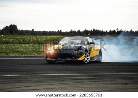 Car drifting, Blurred image diffusion race drift car with lots of smoke from burning tires on speed track Royalty-Free Stock Photo #2285653761