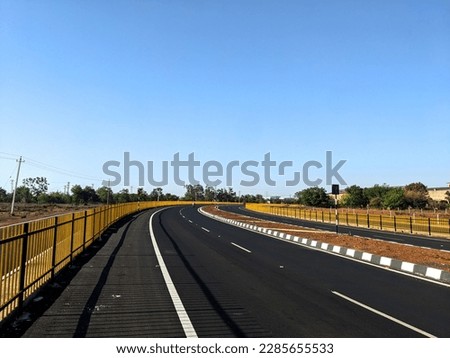 indian highway road with slight curve and blue sky