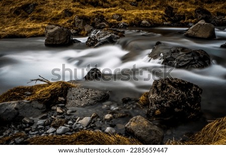 The flow of water in the stream. Water stream flowing. Water stream of cold creek. River stream flowing