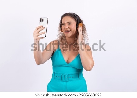 Young caucasian woman with headphones enjoying good music holding a smartphone