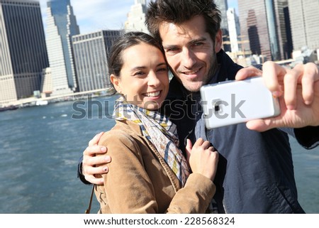 Couple taking picture with Manhattan skyline in background