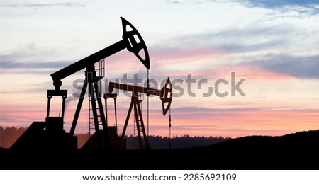 The change in oil prices caused by the war. Oil price cap concept. Oil drilling derricks at desert oilfield. Crude oil production from the ground. Petroleum production. Royalty-Free Stock Photo #2285692109