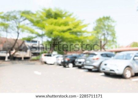 Photo of blurred parking cars in town.