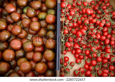 Red homegrown tomatoes and cherry on local farmer agricultural market or supermarket. Healthy vegetarian food. Storage, delivery and sale of fresh vegetables. Small business.