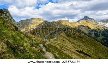View of the High Tatras and Kasprwy Wierch from the red tourist trail leading to the cable-way station on Kasprowy Wierch. A beautiful play of light and shadows on the slopes of the mountains.