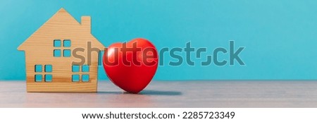 Home model with red heart isolated on blue pastel background
