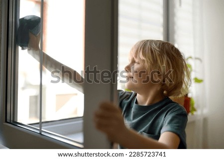 Cute little boy washing a window at home. Child helping parents with household chores, for example, cleaning windows in his house. Children doing housework. Kids household duties Royalty-Free Stock Photo #2285723741