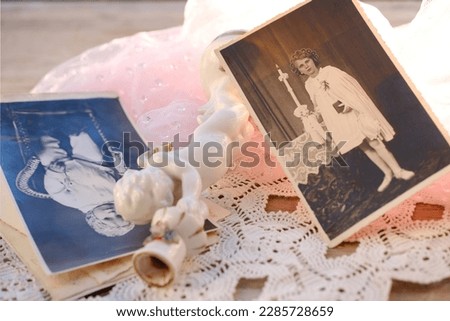 close-up old photographs, porcelain figurine, candlestick Small cupid of Love with golden wings, angel miniature, handmade lace doily, nostalgia and memories, home archive, family tree, genealogy