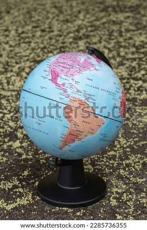 earth globe on a beige textured background showing continent South and North America