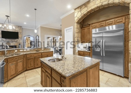 An interior view of a home kitchen with wood cabinets 