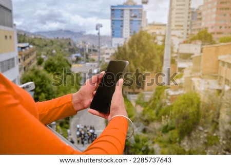 Enjoying the Urban Landscape: Woman at a La Paz Lookout Holding her Cellphone