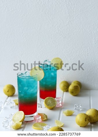 Rainbow mocktail with red syrup, lemon juice, and blue soda, in transparent glass. Perfect for recipe, article, menu book, or any cooking contents.