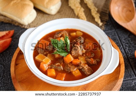 Goulash or Gulasch is a soup or stew of meat and vegetables seasoned with paprika and other spices. Perfect for recipe, article, menu book, or any cooking contents. Royalty-Free Stock Photo #2285737937