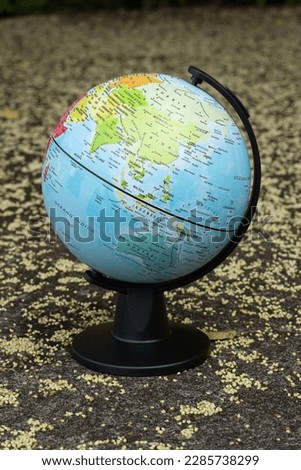 earth globe on a beige textured background showing continent Asia and Oceania
