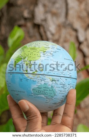 hand holding a terrestrial globe with wooden texture background  Asia and Oceania