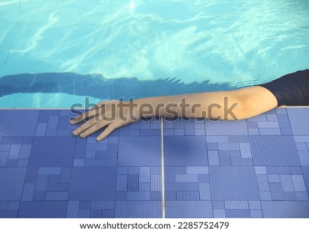 Anti-slip flooring of the swimming pool by the swimmer's arm.