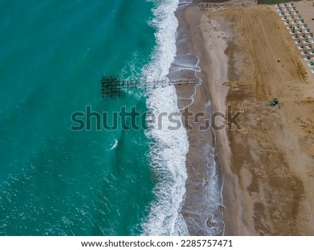 Aerial view of sea crashing waves white foaming waves on seashore rocks top view