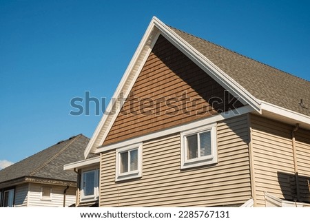 Facade of a house with nice windows in the blue sky background. Beautiful Home Exterior. Real Estate Exterior Front House in a residential neighborhood. Nobody, street photo, copyspace for text