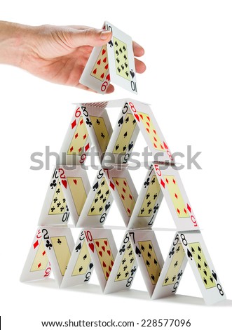 Low-angle view of a man completing a house of cards