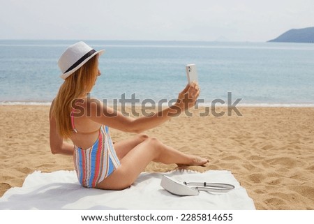Young woman is taking selfie on the beach. Vacation concept