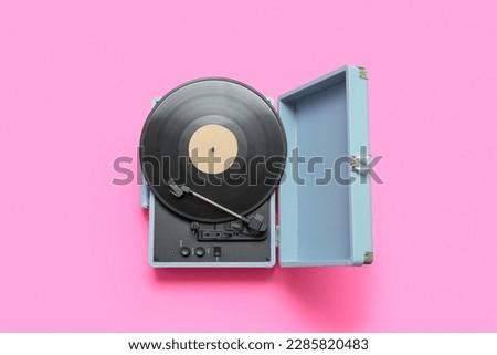 Record player with vinyl disk on pink background Royalty-Free Stock Photo #2285820483