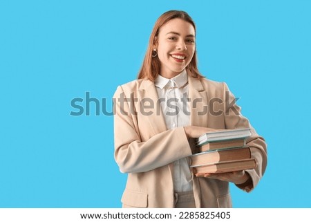 Young woman with books on blue background
