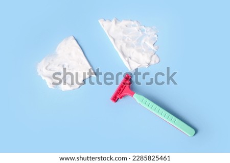 Safety razor and shaving foam on color background Royalty-Free Stock Photo #2285825461