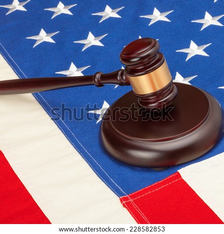 Wooden judge gavel and soundboard laying US flag - closeup shot