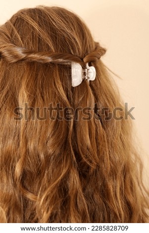 Dark blonde hair twisted back and clasped in a claw clip. Pearlescent hair clip. Trendy hairstyle. Boho hairstyle. Healthy, shiny hair.  Royalty-Free Stock Photo #2285828709