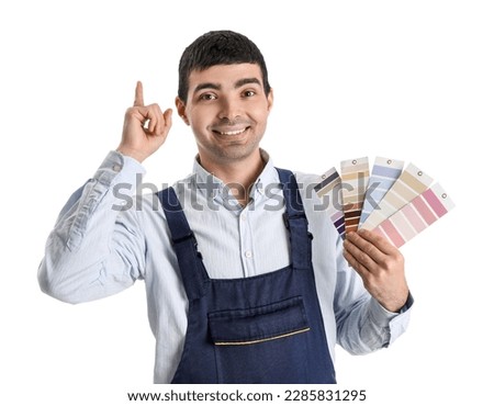 Male painter with color palettes pointing at something on white background