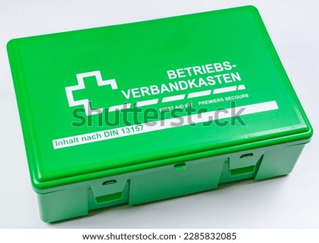 Company first aid kit, German text Betriebs-Verbandkasten and Inhalt nach DIN 13157 on white background prepared for cropping