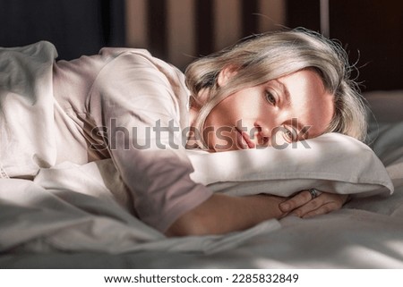 Stressed middle aged woman lying on bed at home and crying. Unhappy woman suffering from nervous tension, emotional disorders, psychological problems, breakup. Frustrated female feeling lonely  Royalty-Free Stock Photo #2285832849