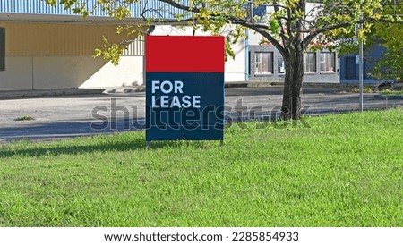 Red and black for lease sign in front of a property