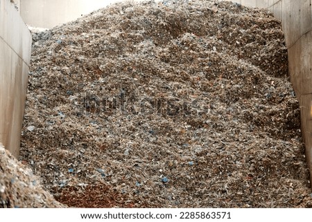 A pile of refuse-derived fuel (RDF) for combustion. Processing municipal solid waste to energy source. Energy resource recovery with waste-to-energy conversion.  Royalty-Free Stock Photo #2285863571