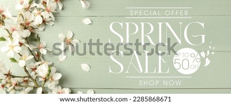 Beautiful blossoming tree branches on green wooden background. Spring sale