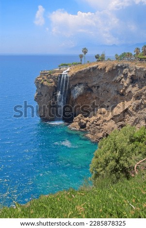 The photo was taken in Turkey. The picture shows a waterfall on the rocky coast of the city of Antalya.